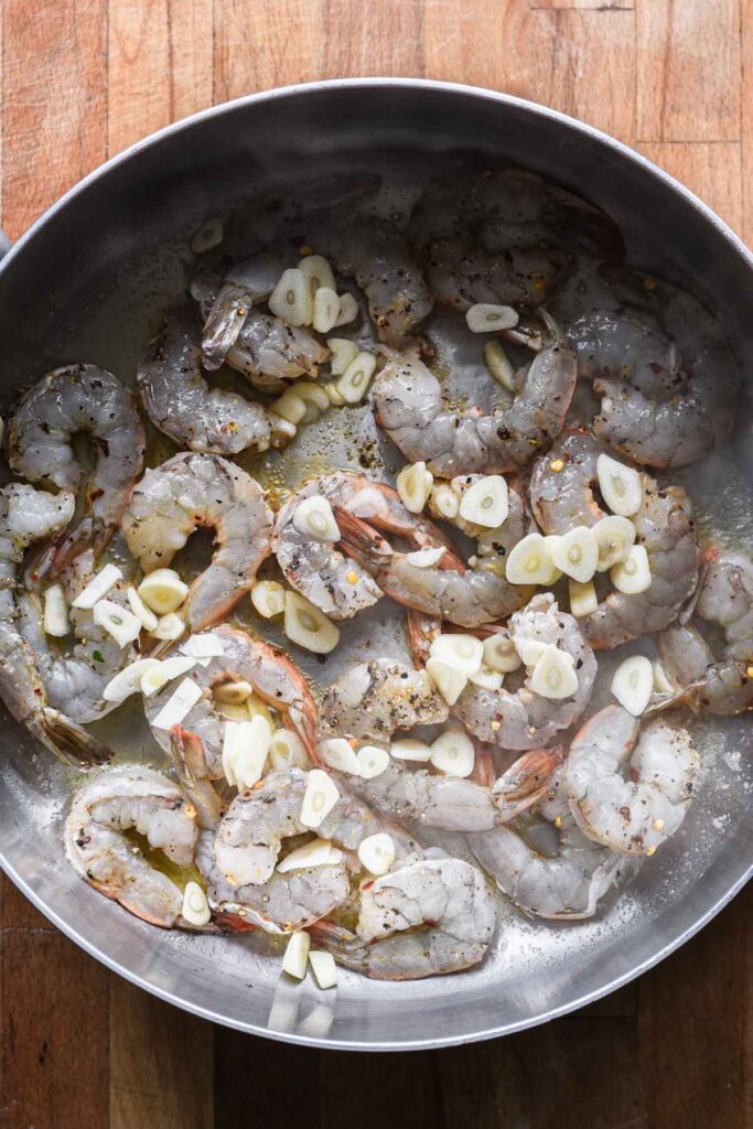 Shrimp and sliced garlic added to the skillet.