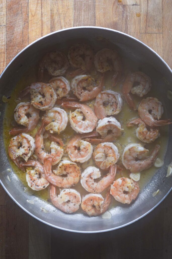 Shrimp cooked on the other side, with lemon juice and wine added to the skillet.