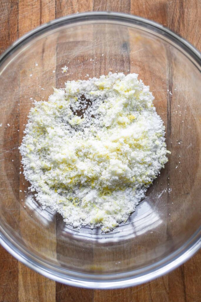 Sugar and lemon zest combined in a bowl.
