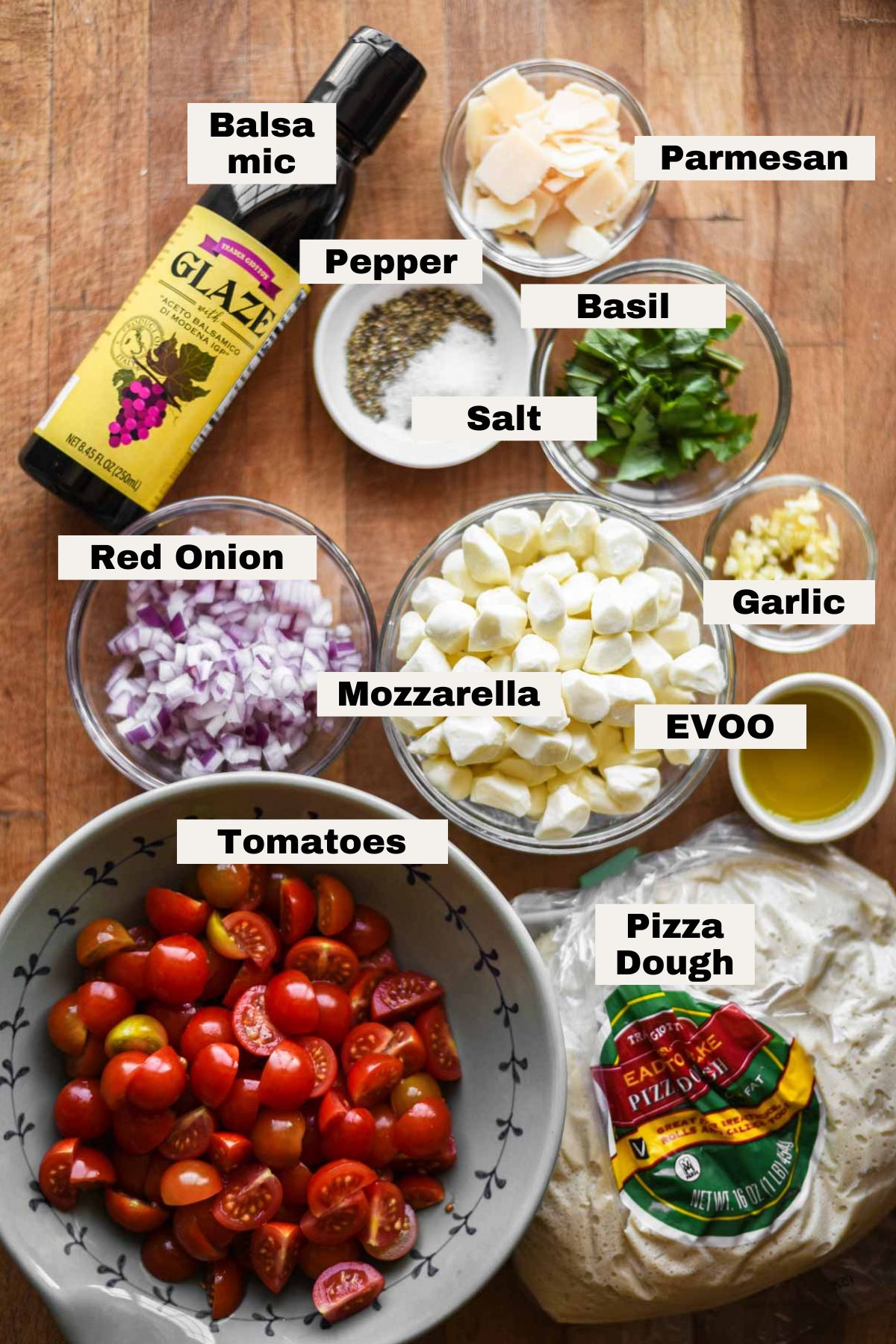 Ingredients labeled on a table for bruschetta pizza.