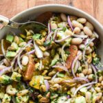 White bean citrus salad in a serving bowl with copy overlay of recipe name.