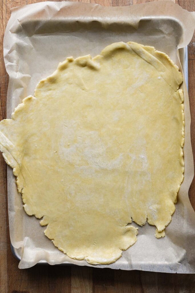 Galette crust dough rolled out onto a baking sheet.